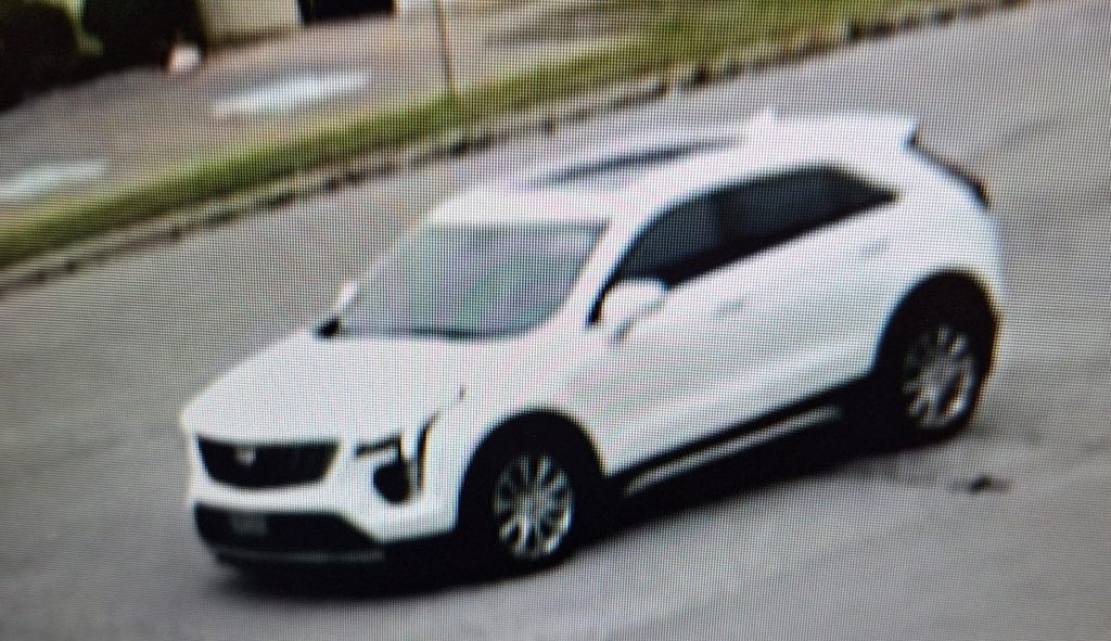 cctv still photo of a newer model white Cadillac SUV 